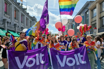 Volters wearing and holding rainbow flags and Volt flags at a Pride march