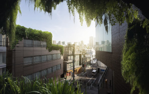 View from a building onto a city with other buildings and lots of vegetation