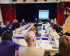 Tables arranged in a square, Volters are sitting at the table, in the background you can see a stage with a screen on which a presentation is running. On the right, George Penn is standing and saying something.