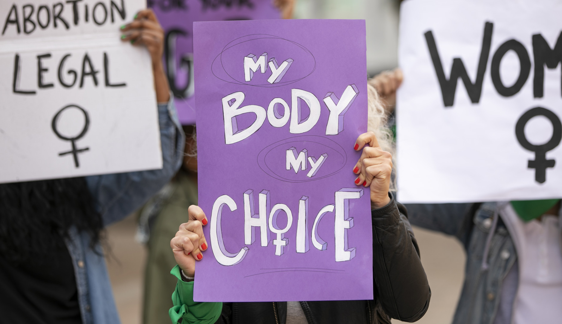 Women holding posters which read