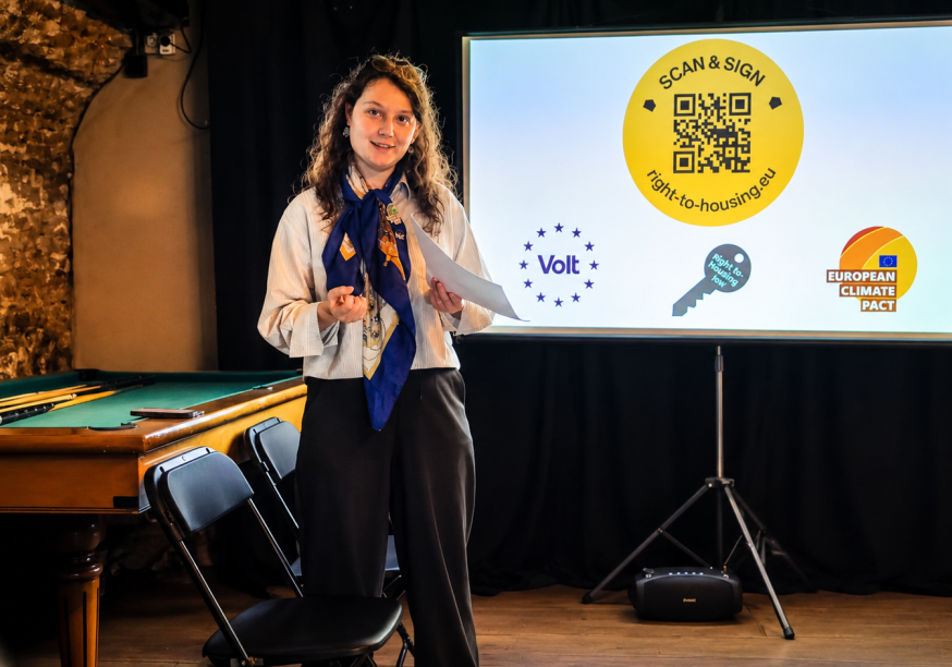 Lucia standing in front of a projection and giving a speech