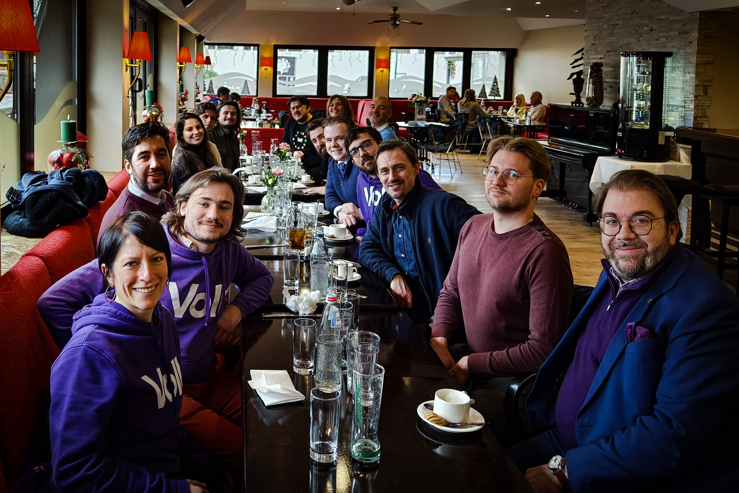 A whole bunch of Volter are sitting at a restaurant table.