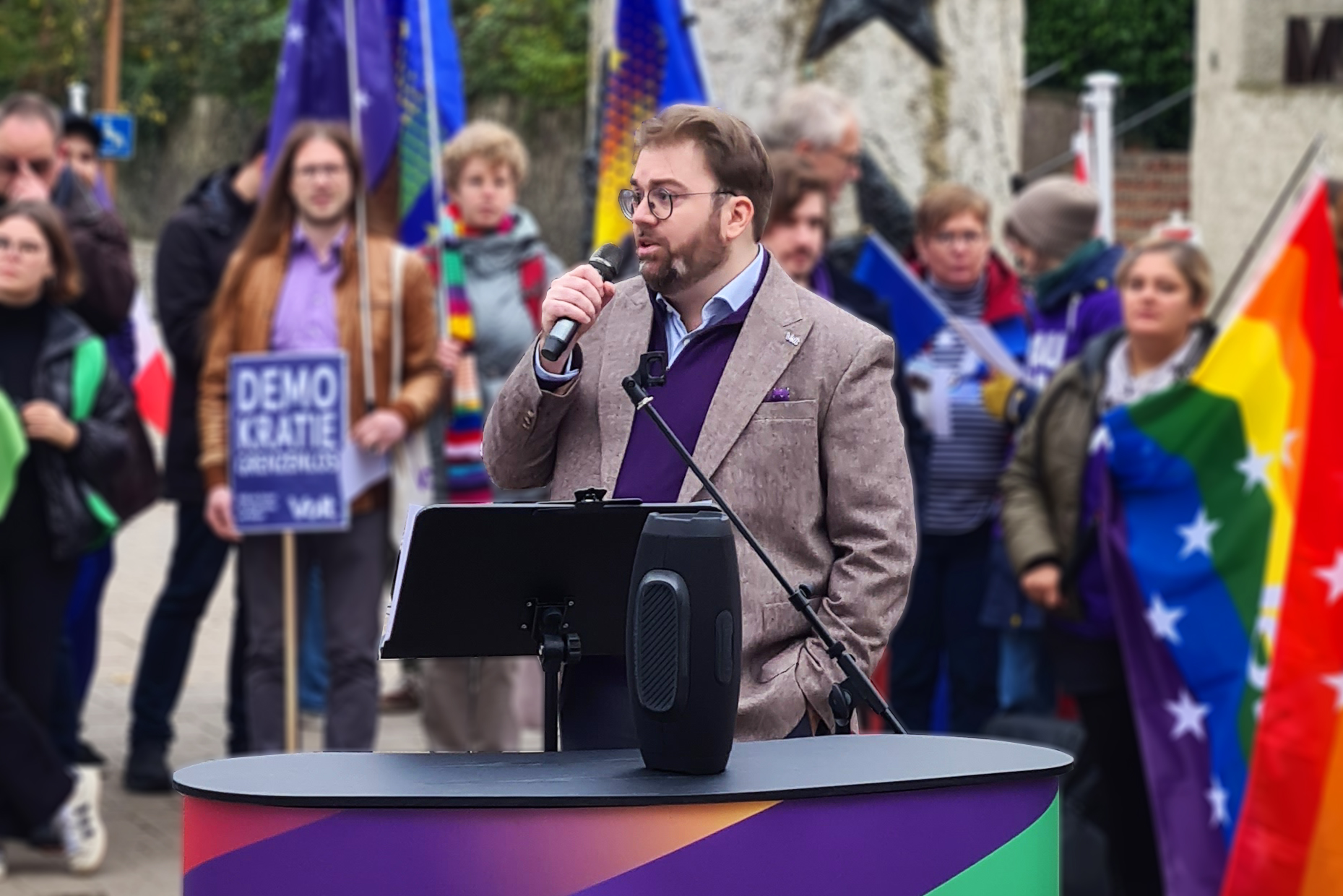 Philippe Schannes from Volt Luxembourg holding a microphone, a crowd in the background